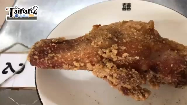 白色圓盤盛著酥炸雞腿，表面撒滿金黃色蒜酥顆粒，色澤誘人