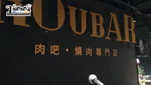 黑底招牌上寫著「ROUBAR」與「肉吧・燒肉專門店」字樣，橘色字體搭配麥克風道具