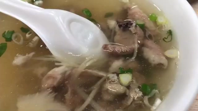 碗中盛著滾肉湯,湯匙舀起肉塊,湯色清澈撒著蔥花