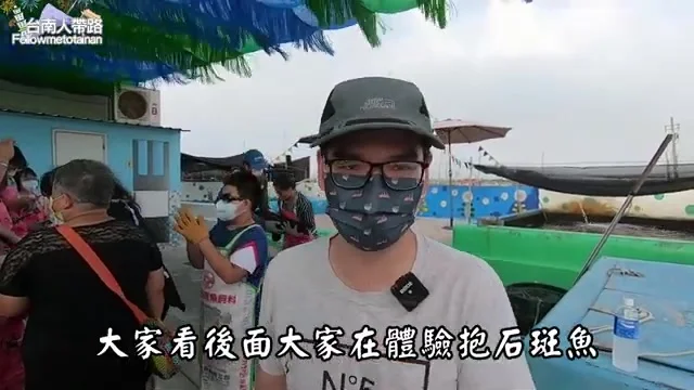 阿波在漁港碼頭介紹體驗抱石斑魚的活動