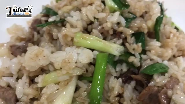 特寫蔥爆豬肉炒飯,米粒油亮均勻裹著醬色,翠綠蔥段點綴其中
