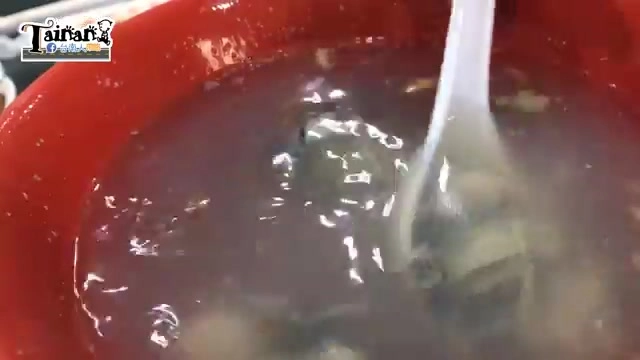 紅色瓷碗盛著豬肝湯,湯色清澈帶淡褐色,可見豬肝與湯料浮於湯面