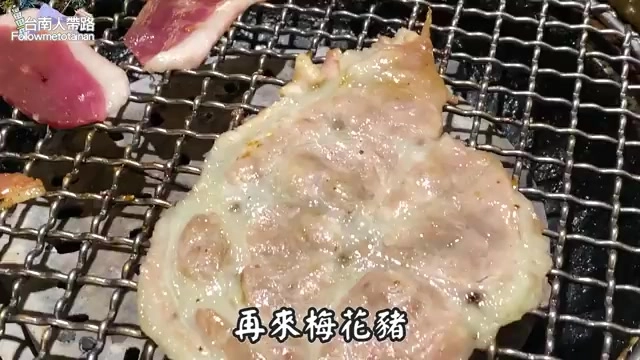 燒烤網上的梅花豬肉正在燒烤，表面微焦帶著油亮光澤
