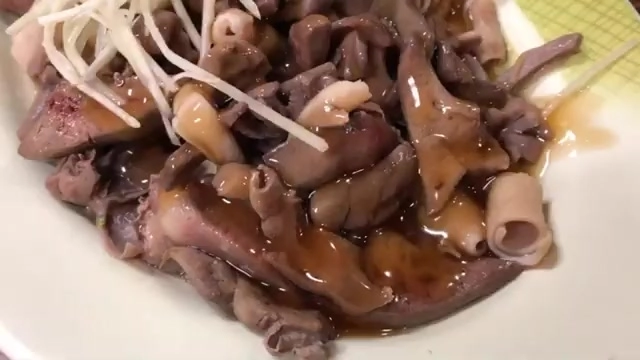 盤中盛著多種鴨內臟部位，淋上醬汁鋪著豆芽菜，色澤深褐油亮