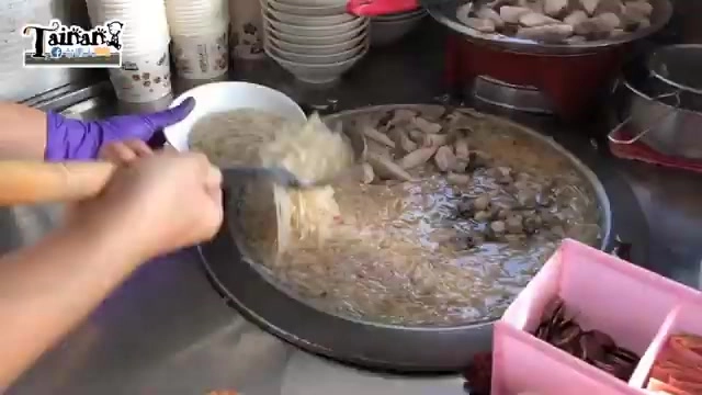 店家在大鍋中翻炒攪拌豆簽羹的湯料，鍋中可見大量食材翻滾