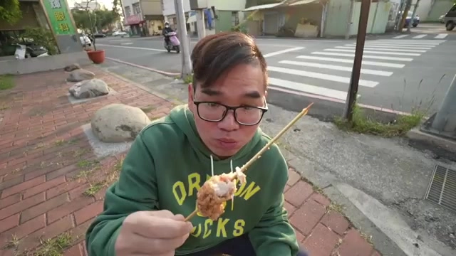 特寫手持的雞肉串，肉塊厚實裹著酥脆外皮，插在竹籤上