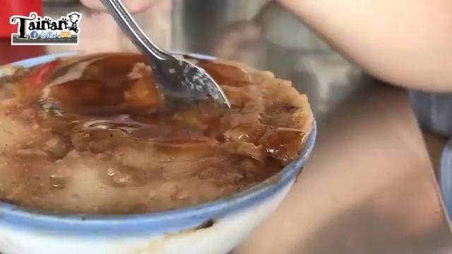 湯匙舀起碗粿一角，可見米漿中夾雜著深色肉燥碎末，質地綿密濕潤