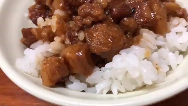 白飯上鋪滿滷得油亮的肉燥塊，色澤深褐帶著光澤