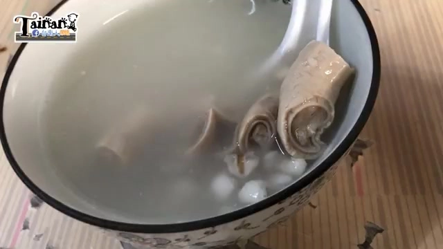 白色花紋瓷碗盛著四神湯，湯色清澈帶白，可見大腸捲與薏仁浮於湯面