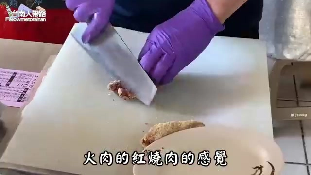 砧板上正在切片的紅糟肉,肉質呈深紅色,一旁擺著切好的肉片