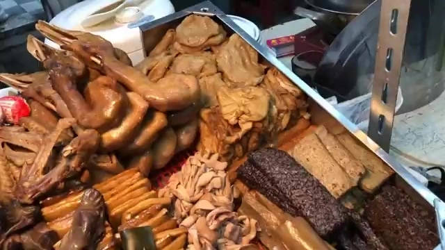 不鏽鋼展示架上陳列著各式滷味,包含鴨翅、豆干、豬皮、米血等品項,色澤深褐油亮