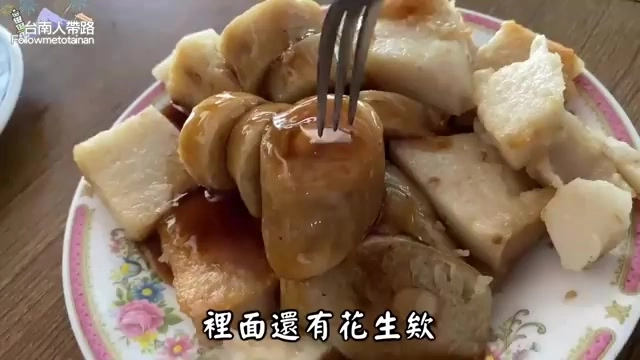 盤中盛著切成塊狀的米糕，淋著醬汁，一旁擺著豆干與其他配菜