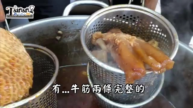 不鏽鋼濾網裡盛著兩條完整燉煮的牛筋，色澤深褐油亮