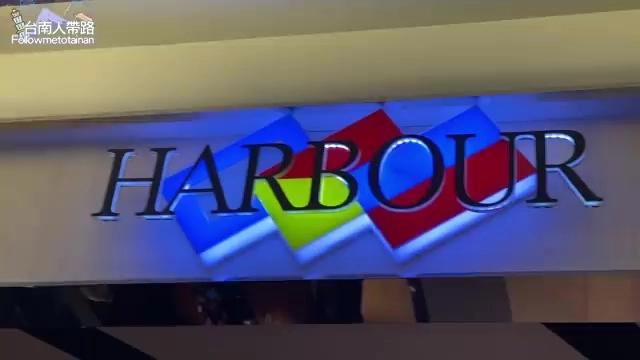 餐廳內牆面上裝設著藍紅相間的「HARBOUR」立體招牌燈箱