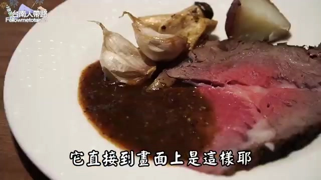 特寫粉紅色帶血水的爐烤牛排切片,佐以烤蒜頭與黑胡椒醬汁
