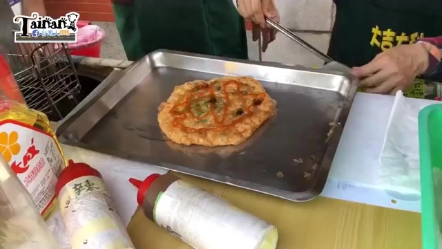 鐵盤上放著剛煎好的蔥肉餅,表面撒著蔥花,形狀不規則帶著焦香紋理