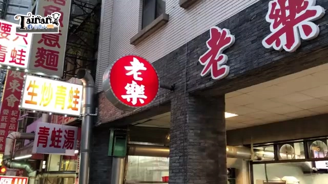 店家招牌，紅底黃字圓形標誌寫著「老樂」，一旁還有其他招牌如「生炒青蛙」「青蛙湯」