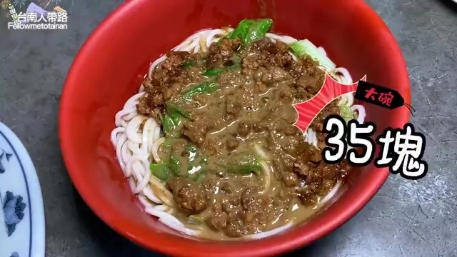 紅色大碗中盛著麻醬麵，淋上濃厚的肉燥醬汁與碎肉，撒著青菜點綴，標示著「大碗35塊」