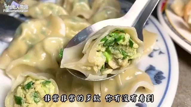 夾起的水餃剖面特寫，內餡飽滿多汁，可見翠綠韭菜與肉餡層次分明