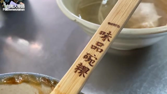 木製叉子上刻著「一味品碗粿」字樣，旁邊擺著湯碗與魚羹