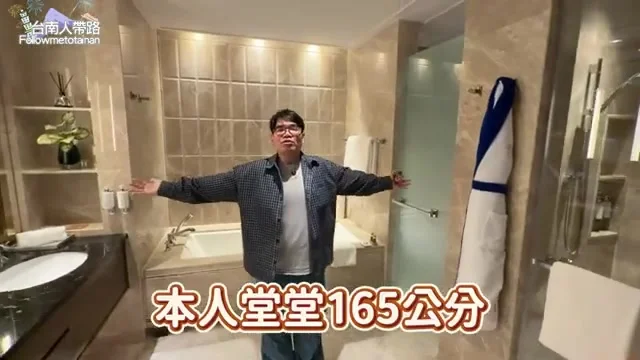 阿波站在浴室裡比出身高手勢,展示空間之大