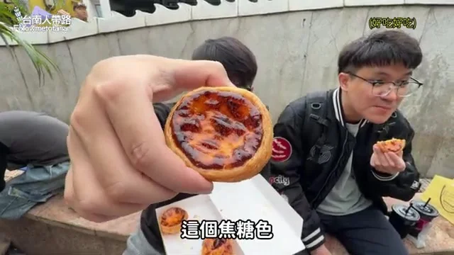阿波拿著一顆安德魯蛋塔特寫,焦糖色澤清晰可見