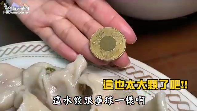 手指捏著一枚硬幣放在水餃旁比對大小，凸顯水餃體積驚人