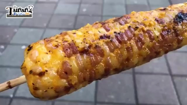 烤玉米特寫,表面裹著油亮的醬汁,顆粒紋理清晰可見,帶著焦香烤紋