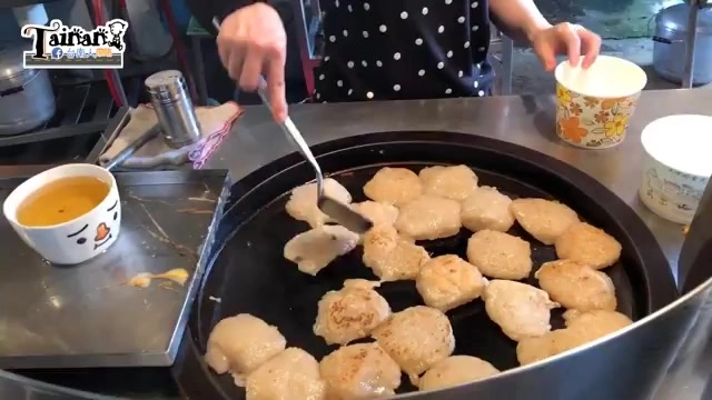 店員在圓形鐵板上煎製多塊肉粿，外皮煎得金黃恰恰