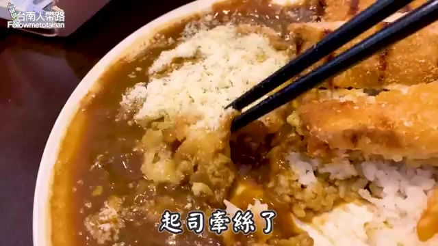 特寫咖哩飯,白飯上淋著濃稠咖哩醬,起司牽絲拉起,一旁擺著炸物與筷子