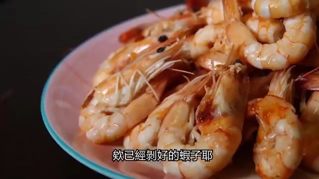 粉色餐盤中盛著多隻已剝殼的鮮蝦,色澤紅潤誘人