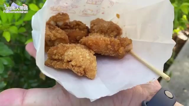 手掌托著剛炸好的雞塊,插著竹籤,外皮金黃酥脆