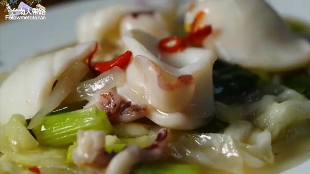 盤中盛著螺肉與花枝拌炒,搭配蔥段與紅辣椒點綴,色澤鮮豔
