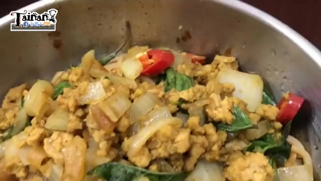 不鏽鋼鍋中盛著炒得金黃的絞肉，搭配洋蔥、紅辣椒與九層塔拌炒