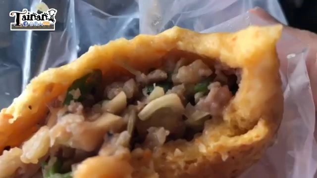 剖開的水煎包內餡特寫，可見豐富的肉末、蔥花與蔬菜料，色澤鮮明