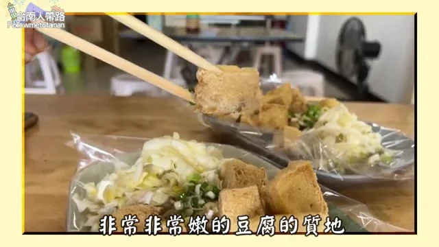 阿波夾起臭豆腐，展示酥脆外皮與嫩豆腐質地