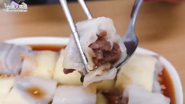 筷子夾起的腸粉皮包裹著肉餡,浸在醬色油亮的湯汁中,粉皮軟嫩透亮