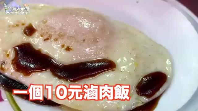 淋著醬色滷肉的白飯，半熟蛋黃緩緩流出，覆蓋在飯上