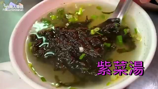 湯匙舀起紫菜湯，湯色清澈，飄著蔥花與紫菜