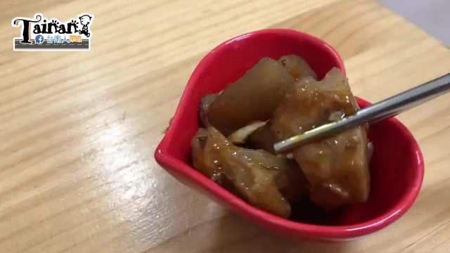 紅色愛心造型小碗盛著滷牛筋，色澤醬紅油亮，筷子夾起一塊