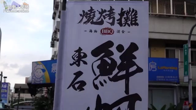 白色布條招牌上以書法字體寫著「燒烤攤」,標示海物BBQ酒食、東石鮮蚵