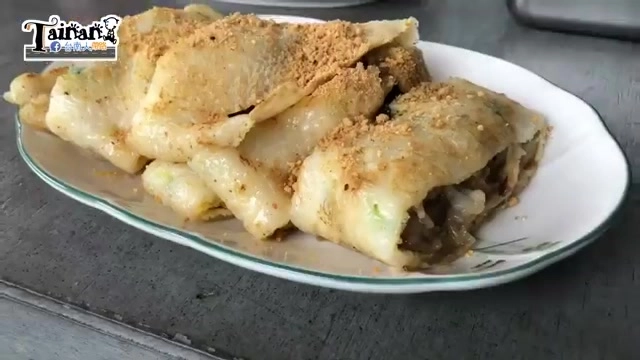 白色瓷盤盛著切片的肉粽蛋餅,表面撒滿花生粉,內餡可見完整肉粽與蛋液交織