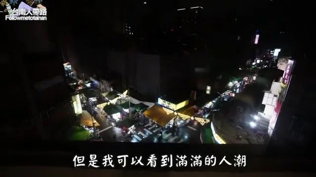 阿波在禾順行旅房間內展示窗景，樓下正對著萬華夜市美食攤位
