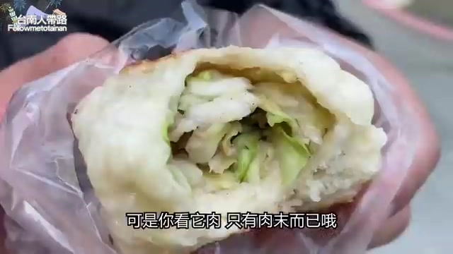 剖開的水煎包內餡露出高麗菜與少許肉末，外皮呈現金黃色澤