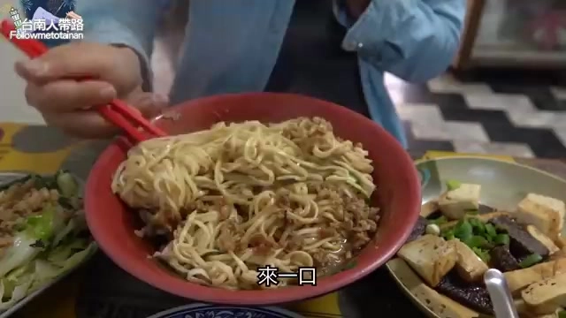 紅色大碗中盛滿麻醬麵,肉燥與麵條交織,份量堆得像小山