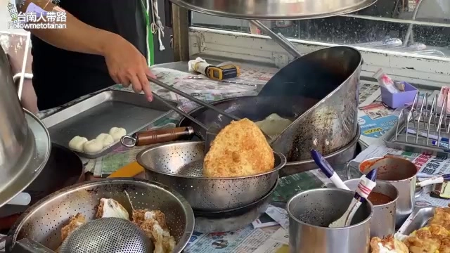 油鍋中正在炸的金黃色蔥油餅,旁邊擺放著漏勺與其他配料