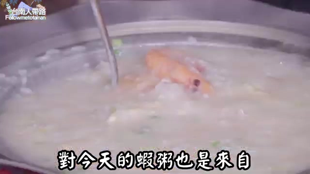 不鏽鋼鍋中熬煮著濃稠的蝦粥，可見完整蝦子與蔬菜點綴其中