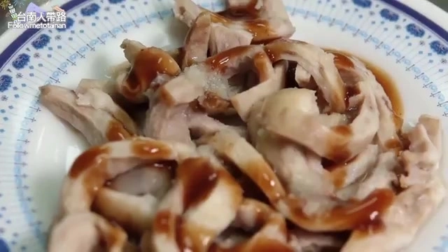 白色瓷盤中盛著切片的豬舌與豬皮，淋上深色醬汁