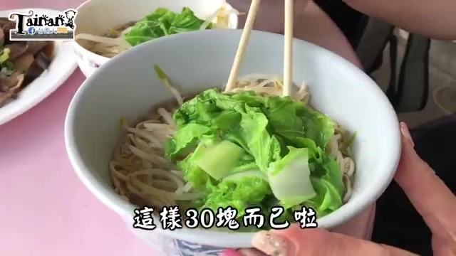 白色瓷碗盛著乾麵，筷子夾起新鮮青菜與豆芽菜，湯汁清澈見底
