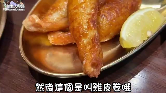 金黃酥脆的雞皮捲搭配檸檬片盛盤，是店家招牌推薦的特色小菜